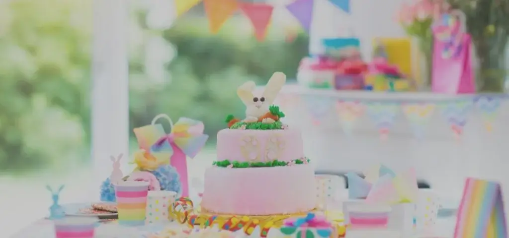 Colourful kids birthday party table with decorated cake and bunting